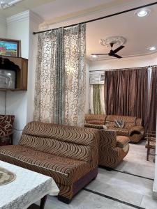 a living room with two couches and a ceiling fan at Stay Royal Imperial in Jammu