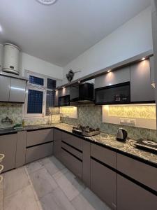 a kitchen with stainless steel appliances and granite counter tops at Stay Royal Imperial in Jammu