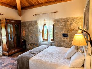 a bedroom with a bed in a room with stone walls at La quercia B&B in Abbateggio