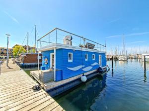 a blue boat is docked at a dock at Hausboot - Yara in Heiligenhafen