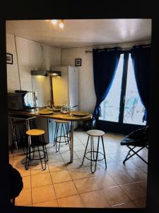 a kitchen with a table and stools in a room at Chalet La Dragonniere in Vias +14 photos