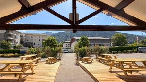 a group of picnic tables on a wooden deck at Fasthotel Thones in Thônes +12 photos
