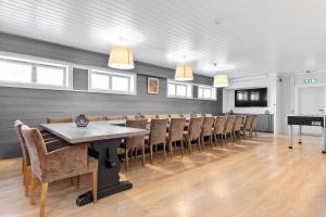 a dining room with a table and chairs and a piano at Gomobu Fjellstue in Ron