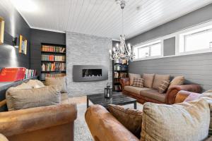 a living room with leather furniture and a fireplace at Gomobu Fjellstue in Ron