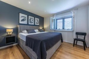 a bedroom with a bed and a chair and a window at NIMA Cozy Stay Mlini in Mlini