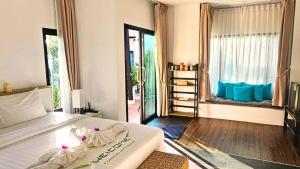 a bedroom with a bed and a large window at La Casa Bangtao Resort in Ban Thalat Choeng Thale +21 photos