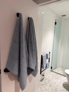 a bathroom with three towels hanging on the wall at Modern Studio in Sydney