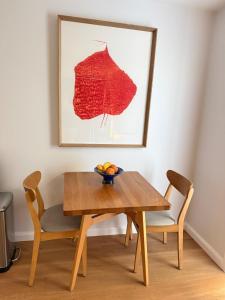 a dining room table with two chairs and a painting at Modern Studio in Sydney