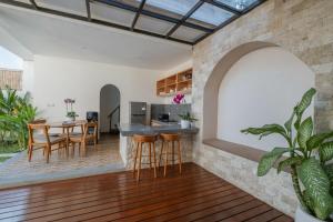an open kitchen and dining room with a table and chairs at Emerald Villas Canggu in Canggu