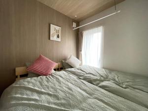 a bedroom with a large bed and a window at イーエフ千歳駅 in Chitose