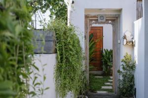 a white house with a door and plants at Emerald Villas Canggu in Canggu