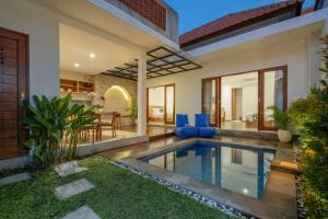a villa with a swimming pool in a backyard at Emerald Villas Canggu in Canggu