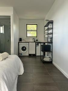 a bedroom with a sink and a washing machine at The Hunter Studio in Cessnock