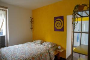 a bedroom with a bed and a yellow wall at Ostello Cresciano in Cresciano