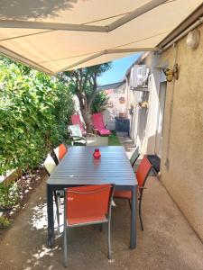 a blue table and chairs under an umbrella at Maison Lauret in Agde