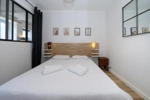 a bedroom with a large white bed with two pillows at Maison Ty Bihan Sioul in Sarzeau