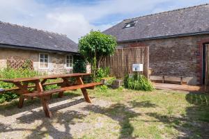 a wooden picnic table in a yard next to a building at Maison Ty Bihan Sioul in Sarzeau