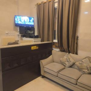 a living room with a couch and a tv at Golden Seasons Rose in Salalah
