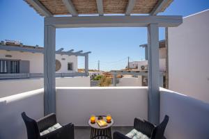 a patio with two chairs and a table on a balcony at Whisper Villa Mykonos in Ano Mera