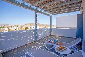 a balcony with a table and chairs on a roof at Whisper Villa Mykonos in Ano Mera
