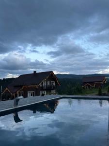 a house with a swimming pool in front of it at Мелодія Гір Вид на гори in Vorokhta