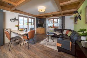 a living room with a couch and a table at Eldorado - Ferienwohnungen & Suiten in Bolsterlang