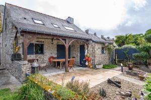 a stone house with a patio with a table at Maison Ty Bao in Sarzeau