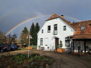 a rainbow in the sky above a white house at Ferienwohnung Zölkow in Kladrum