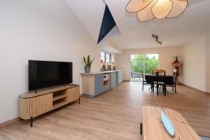 a living room with a flat screen tv and a table at Le Rockin' Chair in Surzur