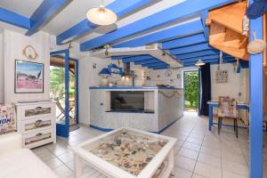a living room with blue ceilings and a fish tank at Maison Ty Bao in Sarzeau