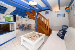 a living room with blue ceilings and a table at Maison Ty Bao in Sarzeau