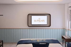 a tv hanging on a wall next to a bed at du PALAIS Hotel in Sultan Thaha Airport