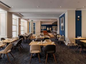 ein Restaurant mit Tischen und Stühlen in einem Raum in der Unterkunft The Novotel Toronto Centre in Toronto