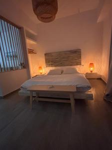 a bedroom with a bed with two lights on the wall at VILLA AKTI in Mochlos