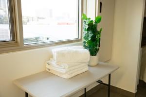 a pile of towels sitting on a table next to a window at Baileys Serviced Apartments in Perth +80 photos