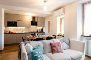 a living room with a white couch and a kitchen at Palazzina Storica al Mare, Rapallo in Rapallo