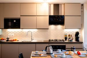 a kitchen with white cabinets and a table with food at Palazzina Storica al Mare, Rapallo in Rapallo