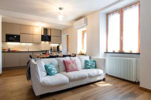 a living room with a white couch and a kitchen at Palazzina Storica al Mare, Rapallo in Rapallo