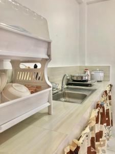 a kitchen with a sink and a counter top at Reinhardshausen Suites and Residences- Lovely Air-Conditioned Units in Tuguegarao City