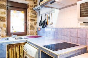 a kitchen with a sink and a stove at Baelo Claudia in Navalguijo