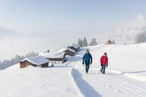 two people walking down a snow covered road at Ferienhaus Victoria in Schruns