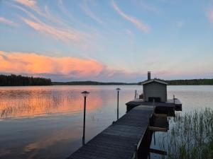 a dock on a lake with two lights on it at Glamping Marsjön & Sauna in Rejböle