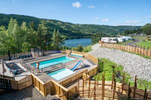 an outdoor swimming pool with a view of a river at Topcamp Rustberg - Hafjell in Hafjell