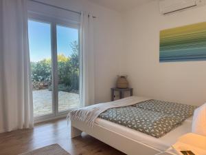a bedroom with a bed and a sliding glass door at Philia-Modern Living with Panoramic Sea View in Kotrónion