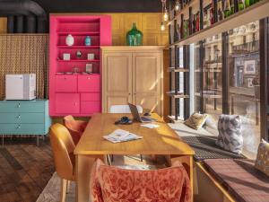 a dining room with a wooden table and pink shelves at Mercure Paris Centre Gare Montparnasse in Paris
