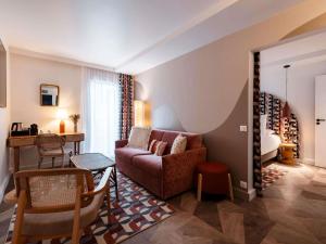 a living room with a couch and a table at Mercure Quiberon Hotel in Quiberon