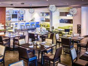 a restaurant with tables and chairs and a bar at Novotel Toronto North York in Toronto