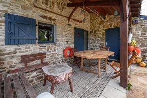a patio with a wooden table and a bench at Maison Ty Bao in Sarzeau +13 photos