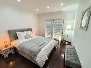 a bedroom with a large bed and a window at Casa com piscina para 10 pessoas - 5 min da praia Esposende in Esposende +23 photos