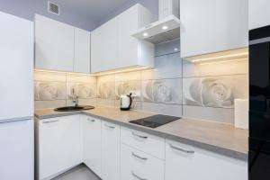 a kitchen with white cabinets and a sink at Nyvky Like Home - Fayna Town - apt 149 8 поверх, 1 буд in Kyiv